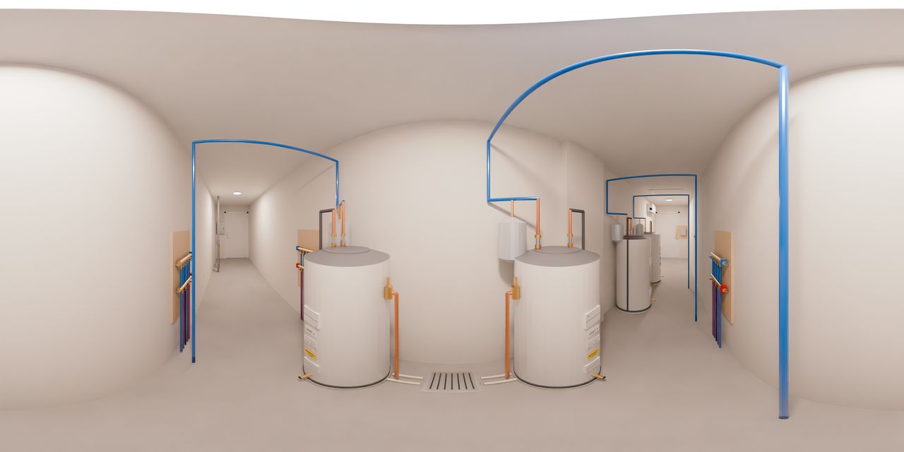 Four 50 gallon water heaters in drain pans, one for each studio, in two pairs with a floor drain between each pair, red and blue water lines on the walls, and a mini-split heat pump high on the wall at the far end.